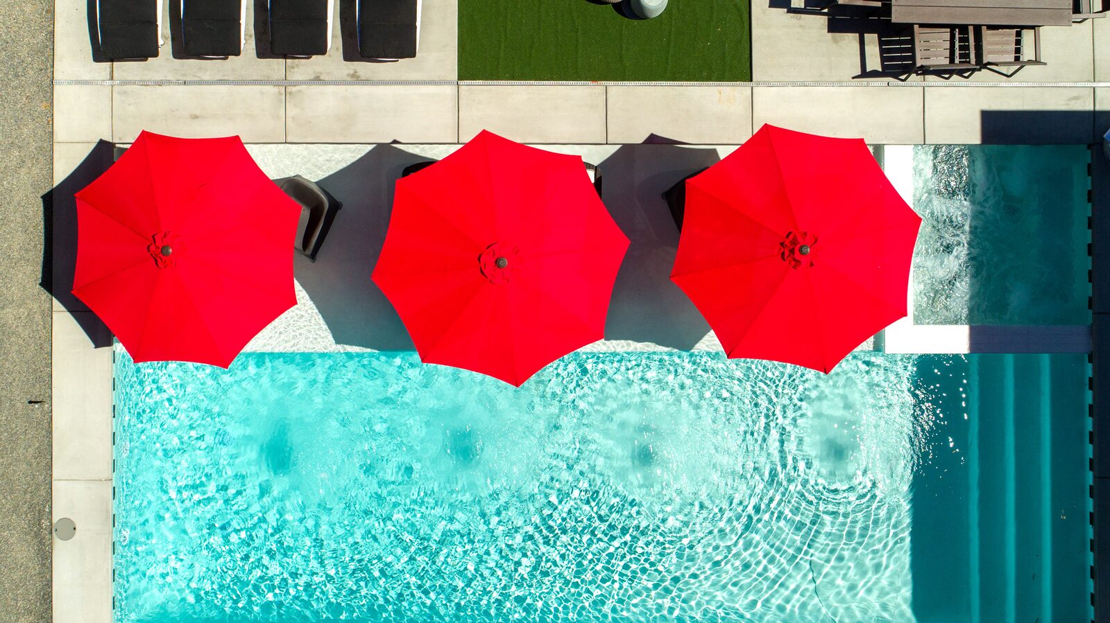 5 Palms Estate saltwater pool with row of red umbrellas overhead