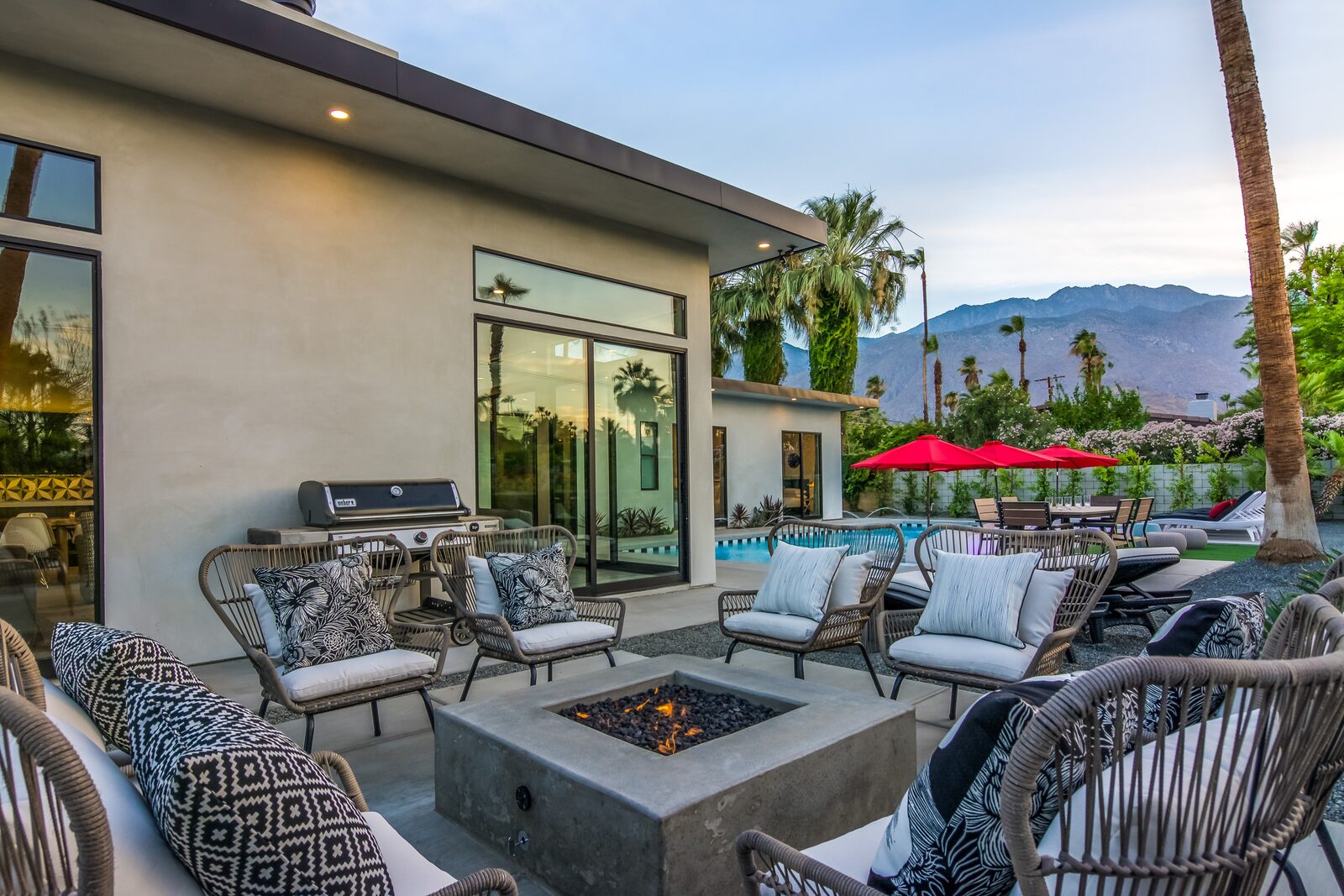 5 Palms Estate outdoor fire pit lounge with grill and pool beyond