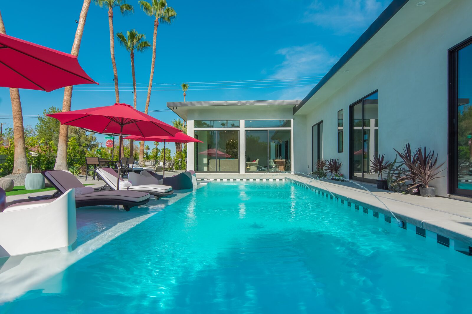 5 Palms Estate saltwater pool with red umbrellas in bright daylight