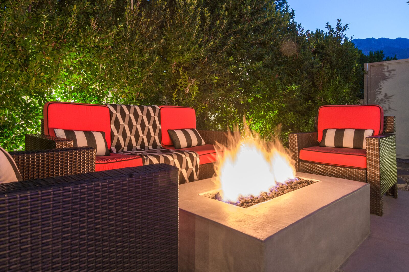 Palms at Park Villa outdoor fire pit with striped lounge chairs at night